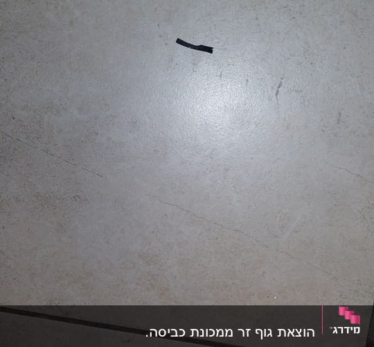 חתיכת חוט שחור על רצפה בהירה